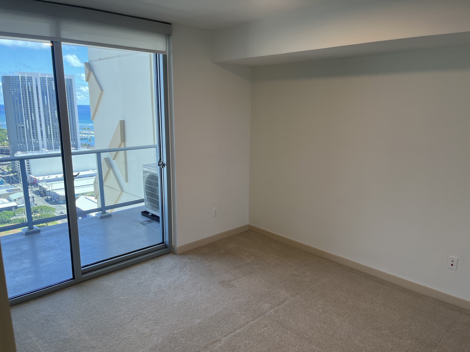 Empty room with a sliding glass door leading to a balcony.